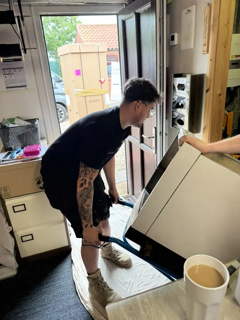 Alfie moving an old boiler out of a property using a sack barrow