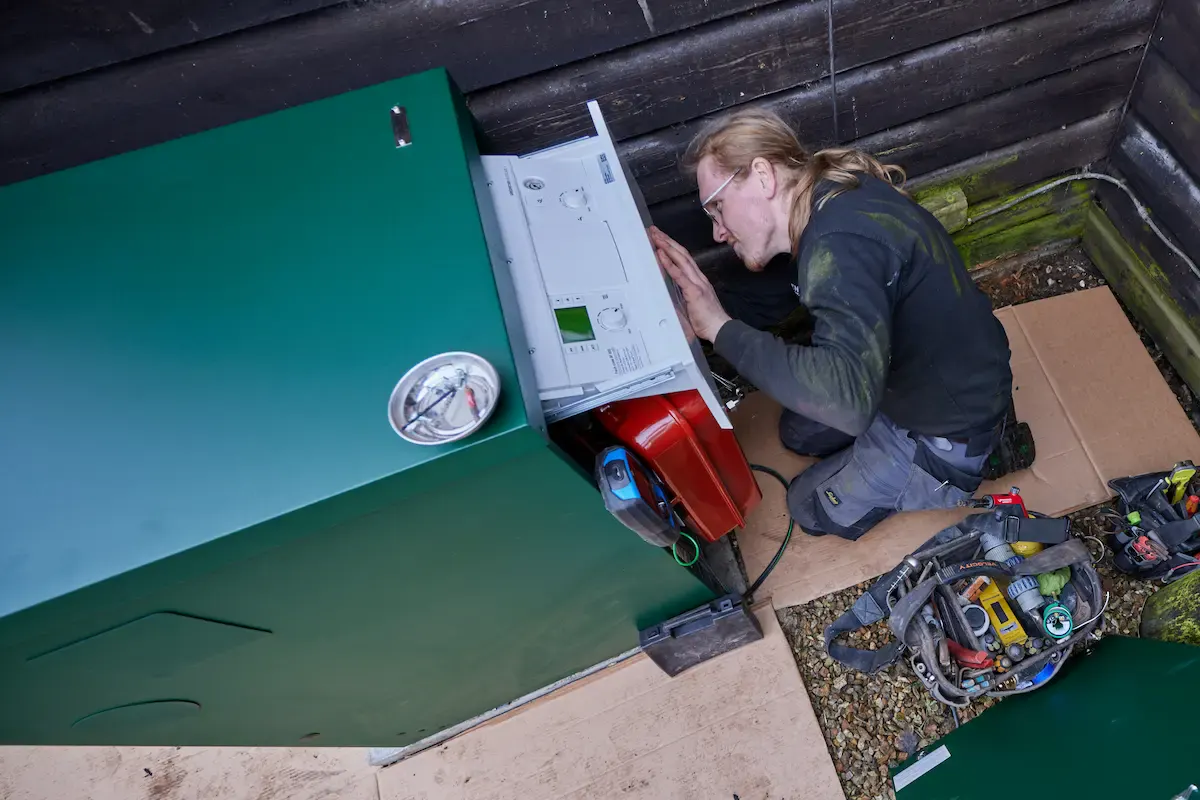 Vector Heat engineer working on an external oil boiler