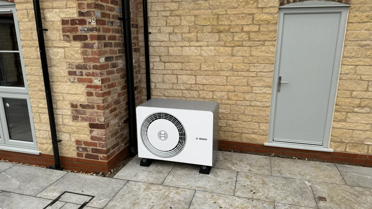 Bosch air source heat pump installed beside a stone house