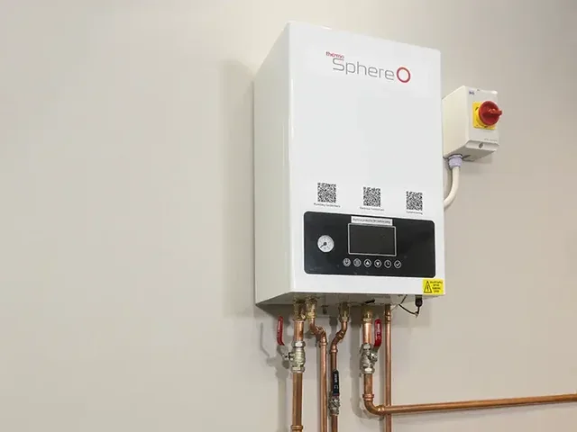 Electric combi boiler installed on an internal wall with copper pipework below