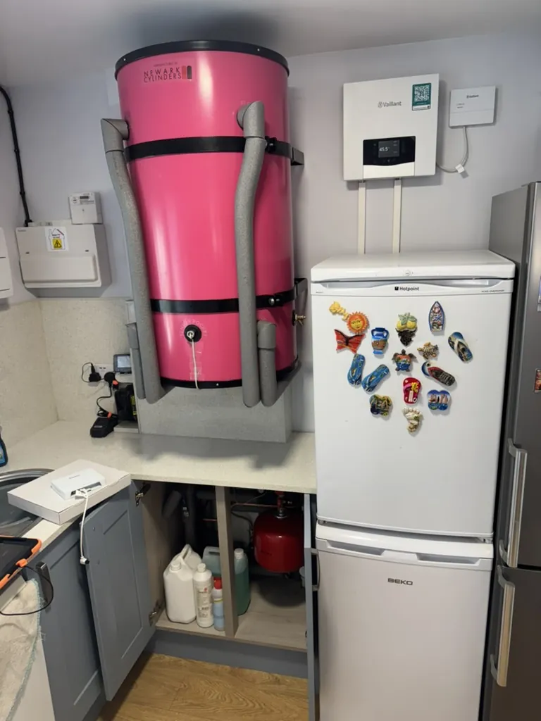 Pink Heat Geek Mini Store mounted above a kitchen worktop beside Vaillant controls