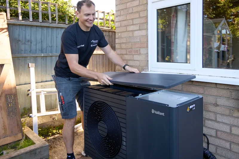 Vector Heat engineer refitting the lid on a Vaillant heat pump