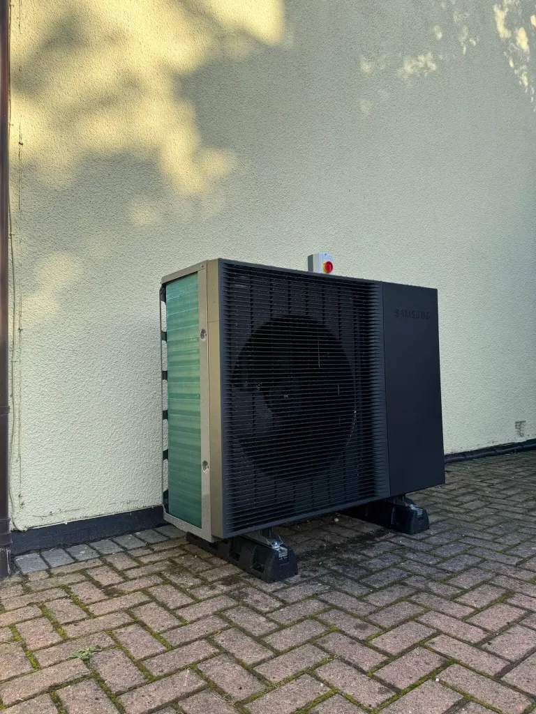 Installed Samsung Gen 7 R290 16kW single-fan heat pump beside a rendered wall